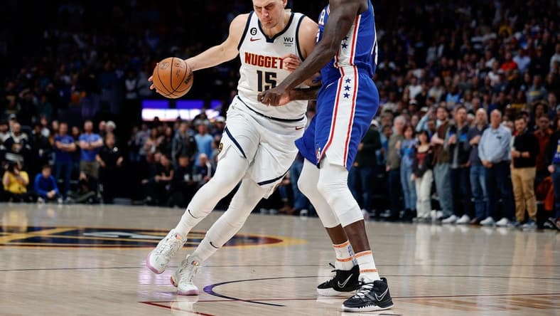 Mar 27, 2023; Denver, Colorado, USA; Denver Nuggets center Nikola Jokic (15) drives to the basket against Philadelphia 76ers center Dewayne Dedmon (14) in the first quarter at Ball Arena. Mandatory Credit: Isaiah J. Downing-USA TODAY Sports