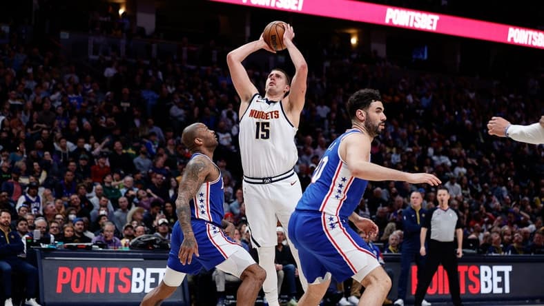 Mar 27, 2023; Denver, Colorado, USA; Denver Nuggets center Nikola Jokic (15) attempts a shot against Philadelphia 76ers forward P.J. Tucker (17) as forward Georges Niang (20) defends in the second quarter at Ball Arena. Mandatory Credit: Isaiah J. Downing-USA TODAY Sports