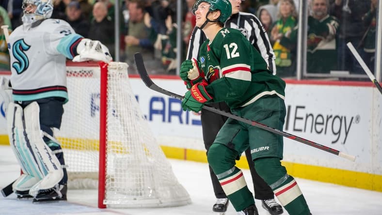 Mar 27, 2023; Saint Paul, Minnesota, USA; Minnesota Wild left wing Matt Boldy (12) looks at the replay of his second goal of the game against the Seattle Kraken in the second period at Xcel Energy Center. Mandatory Credit: Matt Blewett-USA TODAY Sports