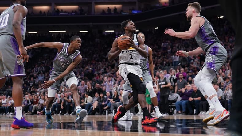 Mar 27, 2023; Sacramento, California, USA; Minnesota Timberwolves guard Anthony Edwards (1) drives to the hoop between Sacramento Kings guard De'Aaron Fox (5) and forward Domantas Sabonis (10) in the second quarter at the Golden 1 Center. Mandatory Credit: Cary Edmondson-USA TODAY Sports