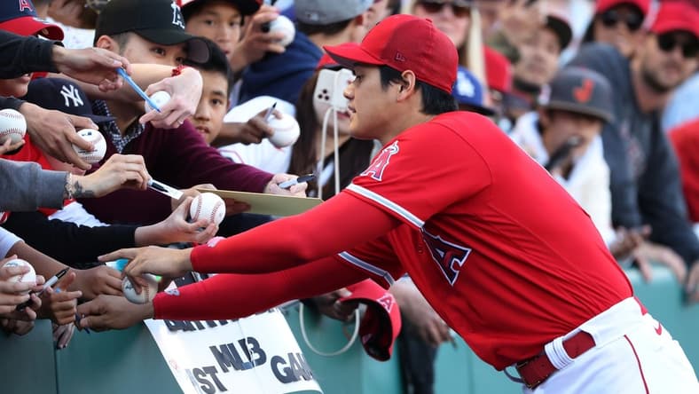 Mar 27, 2023; Anaheim, California, USA; Los Angeles Angels designated hitter Shohei Ohtani (17) signs autographs for fans before a game against the Los Angeles Dodgers at Angel Stadium. Mandatory Credit: Kiyoshi Mio-USA TODAY Sports