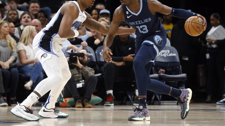 Mar 28, 2023; Memphis, Tennessee, USA; Memphis Grizzlies forward Jaren Jackson Jr. (13) dribbles to the basket as Orlando Magic center Wendell Carter Jr. (34) defends during the first half at FedExForum. Mandatory Credit: Petre Thomas-USA TODAY Sports