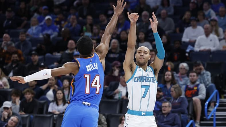 Mar 28, 2023; Oklahoma City, Oklahoma, USA; Charlotte Hornets guard Bryce McGowens (7) shoots a three point basket against Oklahoma City Thunder guard Jared Butler (14) during the second quarter at Paycom Center. Mandatory Credit: Alonzo Adams-USA TODAY Sports