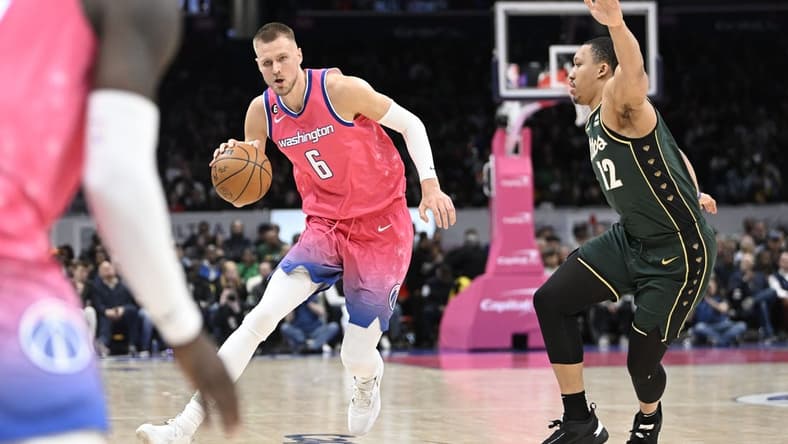 Mar 28, 2023; Washington, District of Columbia, USA; Washington Wizards center Kristaps Porzingis (6) dribbles past Boston Celtics forward Grant Williams (12) during the second half at Capital One Arena. Mandatory Credit: Brad Mills-USA TODAY Sports