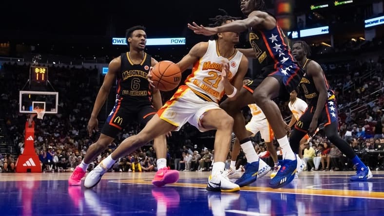 Mar 28, 2023; Houston, TX, USA; East guard DJ Wagner (center) drives to the basket against West forward Baye Fall during the McDonald's All American Boy's high school basketball game at Toyota Center. Mandatory Credit: Mark J. Rebilas-USA TODAY Sports