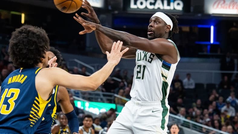 Mar 29, 2023; Indianapolis, Indiana, USA; Milwaukee Bucks guard Jrue Holiday (21) passes the ball while Indiana Pacers forward Jordan Nwora (13) defends in the second quarter at Gainbridge Fieldhouse. Mandatory Credit: Trevor Ruszkowski-USA TODAY Sports
