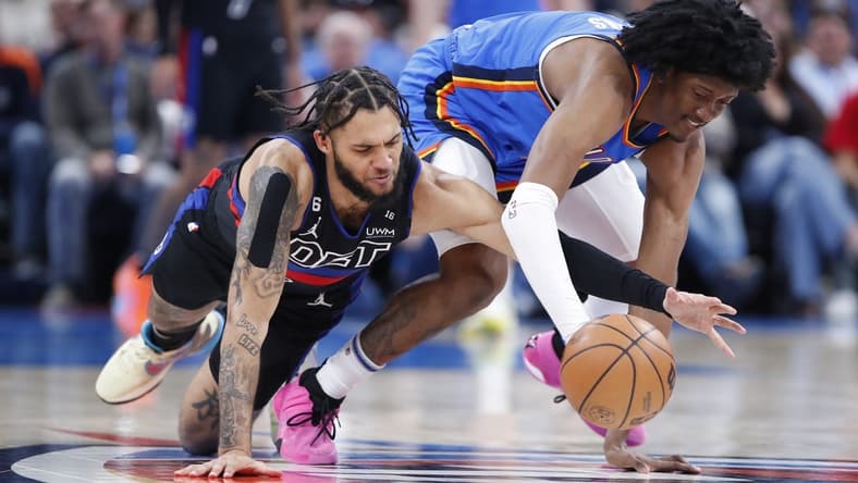 Mar 29, 2023; Oklahoma City, Oklahoma, USA;  Detroit Pistons forward Isaiah Livers (12) and Oklahoma City Thunder forward Jalen Williams (8) drive for a loose ball during the second quarter at Paycom Center. Mandatory Credit: Alonzo Adams-USA TODAY Sports