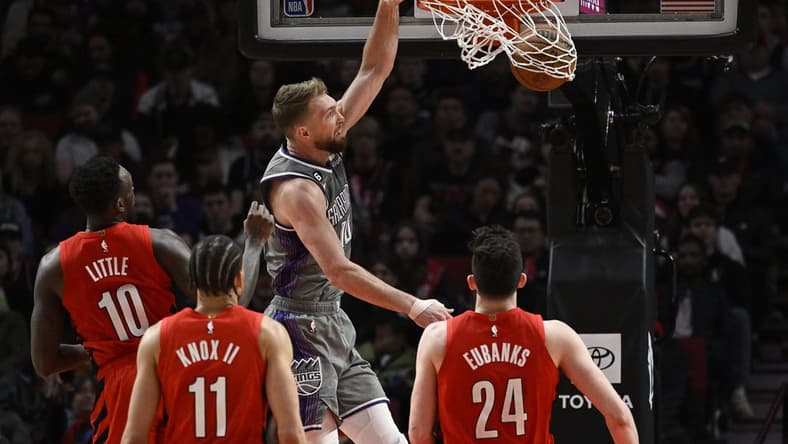 Mar 29, 2023; Portland, Oregon, USA; Sacramento Kings forward Domantas Sabonis (10) dunks the basketball during the first half against Portland Trail Blazers forward Nassir Little (10) at Moda Center. Mandatory Credit: Troy Wayrynen-USA TODAY Sports
