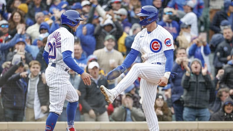 Mar 30, 2023; Chicago, Illinois, USA; Chicago Cubs second baseman Nico Hoerner (2) celebrates with second baseman Miles Mastrobuoni (20) after they both scored against the Milwaukee Brewers during the third inning at Wrigley Field. Mandatory Credit: Kamil Krzaczynski-USA TODAY Sports
