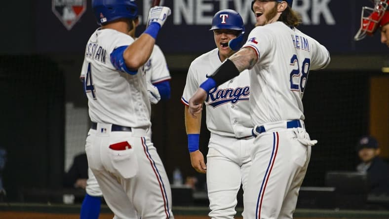Mar 30, 2023; Arlington, Texas, USA; Texas Rangers right fielder Robbie Grossman (4) and catcher Jonah Heim (28) celebrates after Grossman hits a two run home run against the Philadelphia Phillies during the fourth inning at Globe Life Field. Mandatory Credit: Jerome Miron-USA TODAY Sports