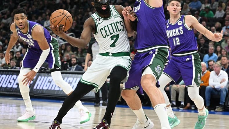 Mar 30, 2023; Milwaukee, Wisconsin, USA; Boston Celtics guard Jaylen Brown (7) drives to the basket against Milwaukee Bucks center Brook Lopez (11) at Fiserv Forum. Mandatory Credit: Michael McLoone-USA TODAY Sports