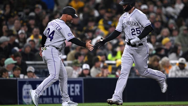 Mar 30, 2023; San Diego, California, USA; Colorado Rockies first baseman C.J. Cron (25) is congratulated by third base coach Warren Schaeffer (34) after hitting a three-run home run during the fifth inning at Petco Park. Mandatory Credit: Orlando Ramirez-USA TODAY Sports