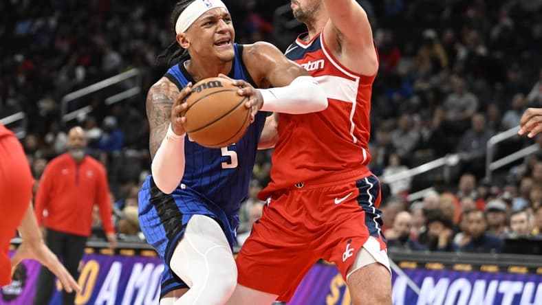 Mar 31, 2023; Washington, District of Columbia, USA; Orlando Magic forward Paolo Banchero (5) dribbles as Washington Wizards forward Deni Avdija (9) defends during the first half at Capital One Arena. Mandatory Credit: Brad Mills-USA TODAY Sports