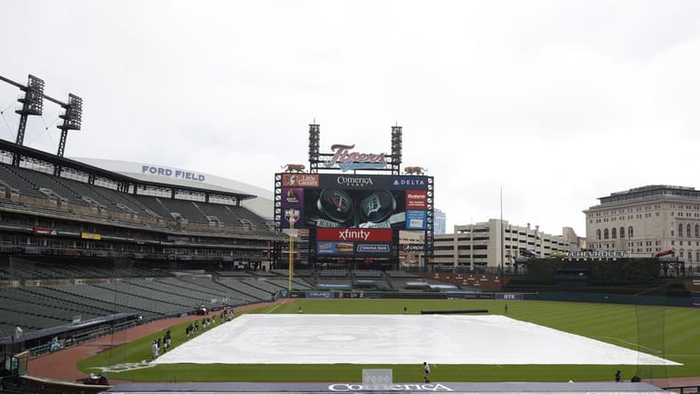 Aug 28, 2020; Detroit, Michigan, USA; The grounds crew prepares to take the tarp off the infield during a weather delay before the game between the Detroit Tigers and the Minnesota Twins on Jackie Robinson Day at Comerica Park. Mandatory Credit: Raj Mehta-USA TODAY Sports