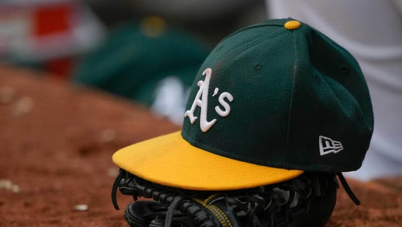 Jun 30, 2021; Oakland, California, USA;  General view of the Oakland Athletics hat and glove during the third inning against the Texas Rangers at RingCentral Coliseum. Mandatory Credit: Stan Szeto-USA TODAY Sports