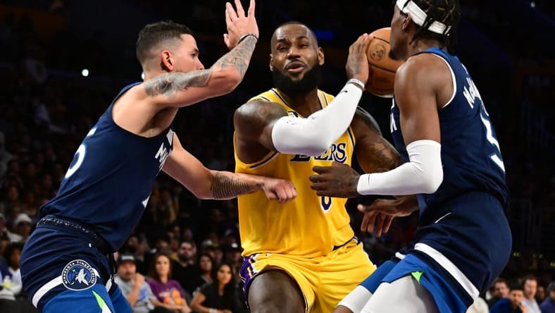 Oct 12, 2022; Los Angeles, California, USA; Los Angeles Lakers forward LeBron James (6) drives through Minnesota Timberwolves Jaden McDaniels (3) and Minnesota Timberwolves guard Austin Rivers (25) during the third quarter at Crypto.com Arena. Mandatory Credit: Richard Mackson-USA TODAY Sports