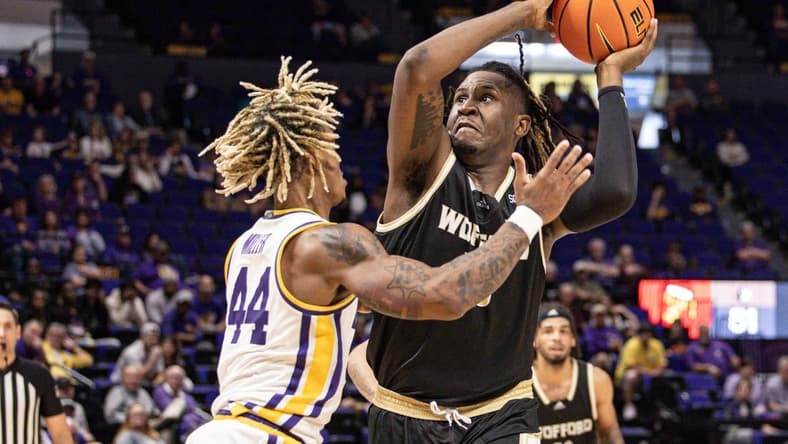 Nov 27, 2022; Baton Rouge, Louisiana, USA; Wofford Terriers forward B.J. Mack (33) drives to the basket against LSU Tigers guard Adam Miller (44) during the second half at Pete Maravich Assembly Center. Mandatory Credit: Stephen Lew-USA TODAY Sports