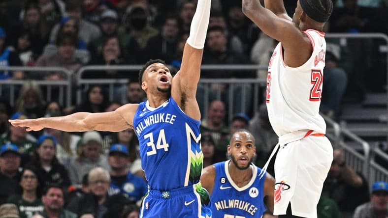 Feb 4, 2023; Milwaukee, Wisconsin, USA; Miami Heat forward Jimmy Butler (22) shoots the ball against Milwaukee Bucks forward Giannis Antetokounmpo (34) in the first half at Fiserv Forum. Mandatory Credit: Michael McLoone-USA TODAY Sports
