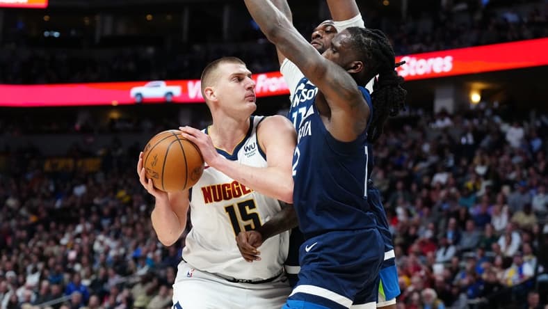 Feb 7, 2023; Denver, Colorado, USA; Minnesota Timberwolves forward Taurean Prince (12) and center Naz Reid (11) defend on Denver Nuggets center Nikola Jokic (15) in the second quarter at Ball Arena. Mandatory Credit: Ron Chenoy-USA TODAY Sports