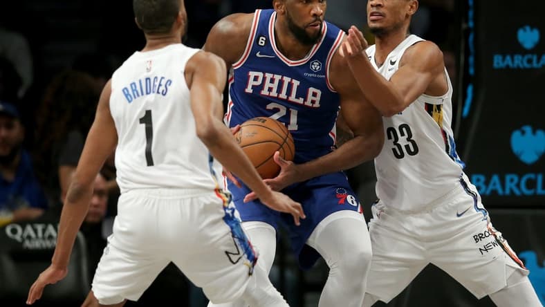 Feb 11, 2023; Brooklyn, New York, USA; Philadelphia 76ers center Joel Embiid (21) drives to the basket against Brooklyn Nets forward Mikal Bridges (1) and center Nic Claxton (33) during the third quarter at Barclays Center. Mandatory Credit: Brad Penner-USA TODAY Sports