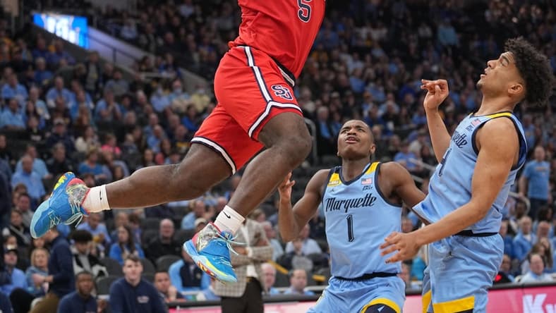 Mar 4, 2023; Milwaukee, Wisconsin, USA; St. John's Red Storm guard Dylan Addae-Wusu (5) scores on Marquette Golden Eagles guard Stevie Mitchell (4) during the second half of their game at Fiserv Forum. Marquette won the Big East Conference regular season championship. Mandatory Credit: Mark Hoffman-USA TODAY Sports