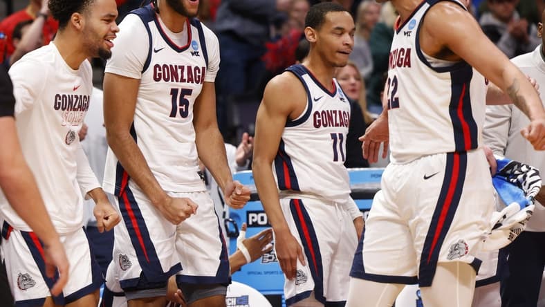 Mar 17, 2023; Denver, CO, USA; Gonzaga Bulldogs bench players including center Efton Reid III (15) and guard Nolan Hickman (11) celebrate with forward Anton Watson (22) during the first half against the Grand Canyon Antelopes at Ball Arena. Mandatory Credit: Michael Ciaglo-USA TODAY Sports
