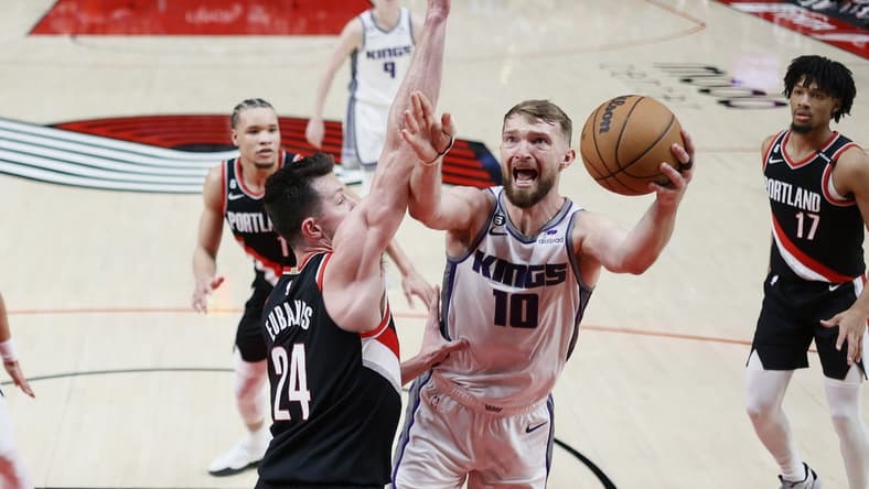 Mar 31, 2023; Portland, Oregon, USA; Sacramento Kings power forward Domantas Sabonis (10) shoots the ball against Portland Trail Blazers power forward Drew Eubanks (24) during the first half at Moda Center. Mandatory Credit: Soobum Im-USA TODAY Sports