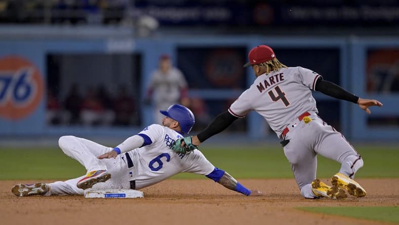 Mar 31, 2023; Los Angeles, California, USA;  Los Angeles Dodgers left fielder David Peralta (6) is tagged out by Arizona Diamondbacks second baseman Ketel Marte (4) on a stolen base attempt in the second inning at Dodger Stadium. Mandatory Credit: Jayne Kamin-Oncea-USA TODAY Sports