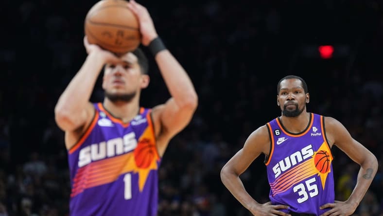 Mar 31, 2023; Phoenix, Arizona, USA; Phoenix Suns forward Kevin Durant (35) watches as Phoenix Suns guard Devin Booker (1) shoots a free throw against the Denver Nuggets during the first half at Footprint Center. Mandatory Credit: Joe Camporeale-USA TODAY Sports