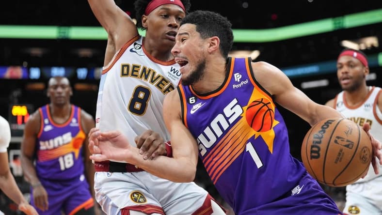 Mar 31, 2023; Phoenix, Arizona, USA; Phoenix Suns guard Devin Booker (1) dribbles against Denver Nuggets forward Peyton Watson (8) during the first half at Footprint Center. Mandatory Credit: Joe Camporeale-USA TODAY Sports