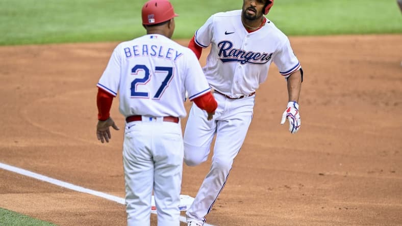 Apr 1, 2023; Arlington, Texas, USA; Texas Rangers second baseman Marcus Semien (2) rounds third base past third base coach Tony Beasley (27) after Semien hits a lead off home run against the Philadelphia Phillies during the first inning at Globe Life Field. Mandatory Credit: Jerome Miron-USA TODAY Sports