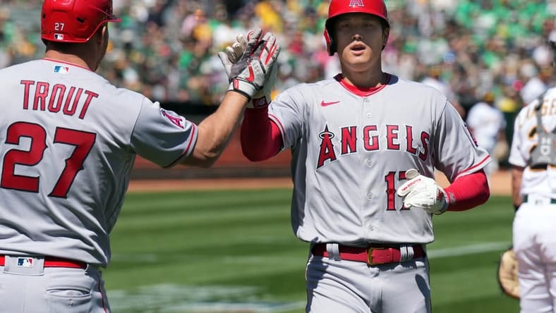 Apr 1, 2023; Oakland, California, USA; Los Angeles Angels designated hitter Shohei Ohtani (17) is congratulated by center fielder Mike Trout (27) after scoring a run against the Oakland Athletics during the third inning at RingCentral Coliseum. Mandatory Credit: Darren Yamashita-USA TODAY Sports