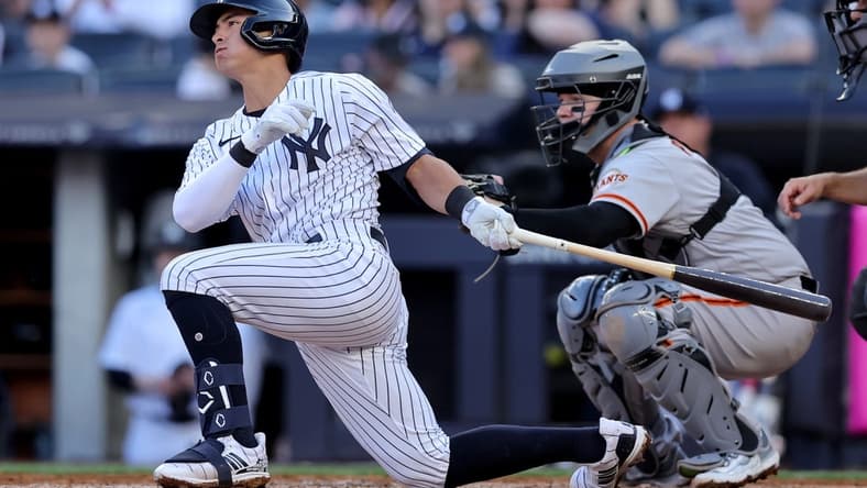 Apr 1, 2023; Bronx, New York, USA; New York Yankees shortstop Anthony Volpe (11) follows through on a single against the San Francisco Giants during the second inning at Yankee Stadium. The hit was hit first major league hit. Mandatory Credit: Brad Penner-USA TODAY Sports