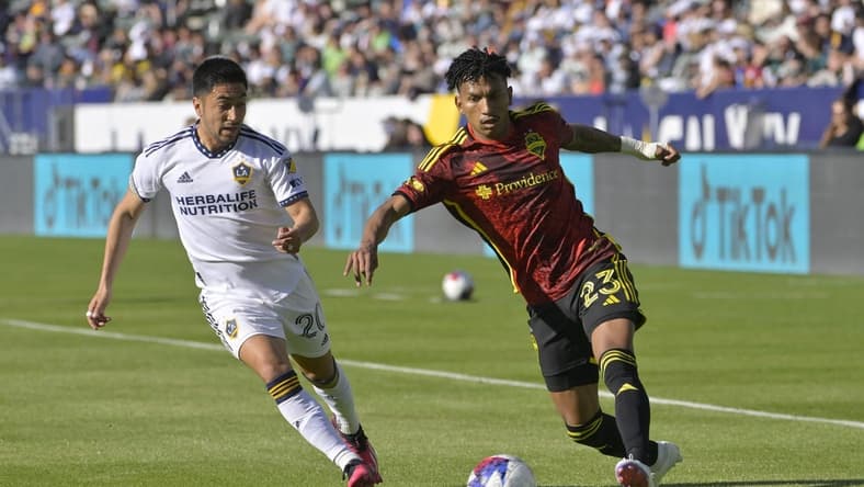 Apr 1, 2023; Carson, California, USA; Seattle Sounders midfielder Leo Chu (23) drives the ball past Los Angeles Galaxy midfielder Memo Rodriguez (20) in the first half against the Los Angeles Galaxy at Dignity Health Sports Park. Mandatory Credit: Jayne Kamin-Oncea-USA TODAY Sports