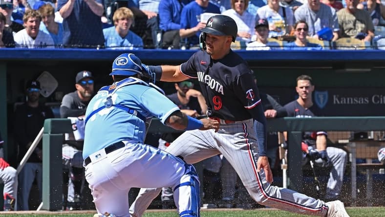 Apr 2, 2023; Kansas City, Missouri, USA; Minnesota Twins left fielder Trevor Larnach (9) is tagged out at home plate by Kansas City Royals catcher Salvador Perez (13) during the second inning at Kauffman Stadium. Mandatory Credit: Peter Aiken-USA TODAY Sports