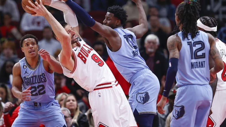 Apr 2, 2023; Chicago, Illinois, USA; Memphis Grizzlies forward Jaren Jackson Jr. (13) fouls Chicago Bulls center Nikola Vucevic (9) during the first half at United Center. Mandatory Credit: Kamil Krzaczynski-USA TODAY Sports