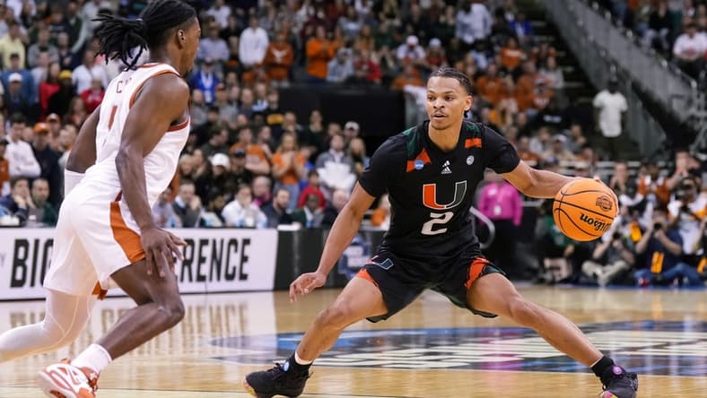 Mar 26, 2023; Kansas City, MO, USA; Miami (Fl) Hurricanes guard Isaiah Wong (2) dribbles the ball against Texas Longhorns guard Marcus Carr (5) during the second half of an Elite 8 college basketball game in the Midwest Regional of the 2023 NCAA Tournament at T-Mobile Center. Mandatory Credit: Jay Biggerstaff-USA TODAY Sports