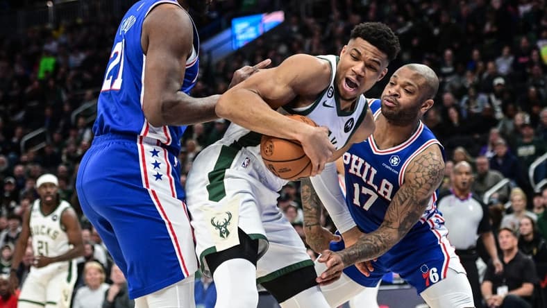 Apr 2, 2023; Milwaukee, Wisconsin, USA; Milwaukee Bucks forward Giannis Antetokounmpo (34) fights for the ball against Philadelphia 76ers forward P.J. Tucker (17) and forward Joel Embiid (21) during the first quarter at Fiserv Forum. Mandatory Credit: Benny Sieu-USA TODAY Sports