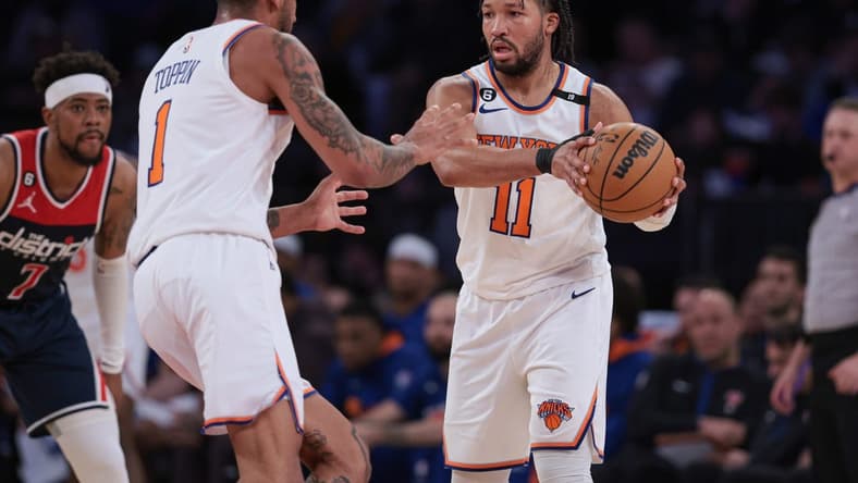 Apr 2, 2023; New York, New York, USA; New York Knicks guard Jalen Brunson (11) sets the ball for forward Obi Toppin (1) in front of Washington Wizards guard Jordan Goodwin (7) during the second half at Madison Square Garden. Mandatory Credit: Vincent Carchietta-USA TODAY Sports