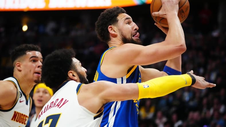 Apr 2, 2023; Denver, Colorado, USA; Golden State Warriors guard Klay Thompson (11) shoots past Denver Nuggets guard Jamal Murray (27) in the second quarter at Ball Arena. Mandatory Credit: Ron Chenoy-USA TODAY Sports