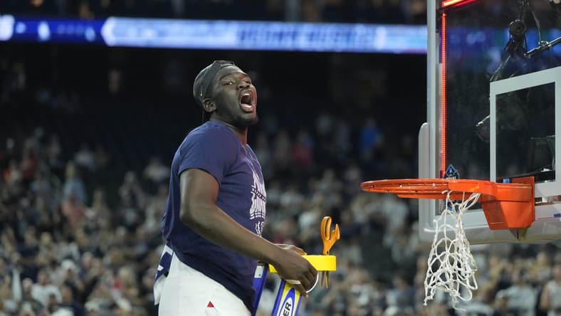 Apr 3, 2023; Houston, TX, USA; Connecticut Huskies forward Adama Sanogo (21) celebrates while cutting down the net after defeating the San Diego State Aztecs in the national championship game of the 2023 NCAA Tournament at NRG Stadium. Mandatory Credit: Bob Donnan-USA TODAY Sports