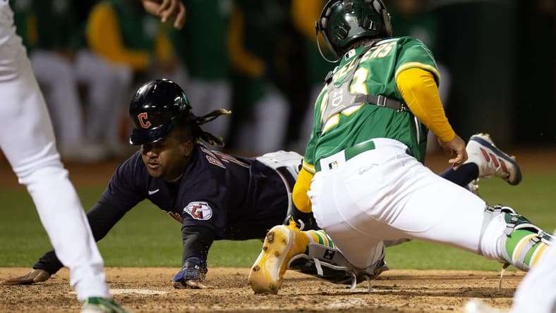 Apr 3, 2023; Oakland, California, USA; Cleveland Guardians third baseman Jose Ramirez (11) eludes the tag by Oakland Athletics catcher Shea Langeliers (23) as he scores on a sacrifice fly by Josh Bell during the eighth inning at RingCentral Coliseum. Mandatory Credit: D. Ross Cameron-USA TODAY Sports