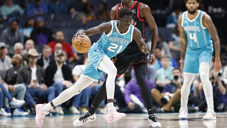 Apr 4, 2023; Charlotte, North Carolina, USA; Charlotte Hornets forward JT Thor (21) drives into Toronto Raptors forward Pascal Siakam (43) as center Nick Richards (4) looks on during the first half at Spectrum Center. Mandatory Credit: Nell Redmond-USA TODAY Sports