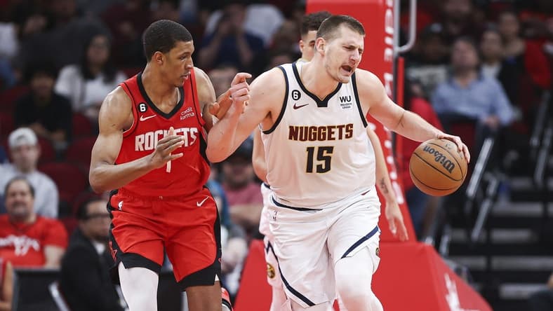 Apr 4, 2023; Houston, Texas, USA; Denver Nuggets center Nikola Jokic (15) dribbles the ball as Houston Rockets forward Jabari Smith Jr. (1) defends during the third quarter at Toyota Center. Mandatory Credit: Troy Taormina-USA TODAY Sports