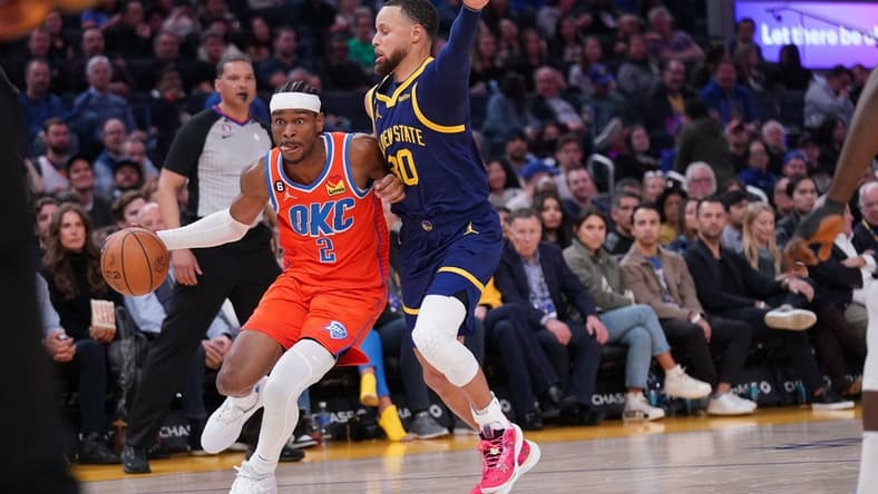 Apr 4, 2023; San Francisco, California, USA; Oklahoma City Thunder guard Shai Gilgeous-Alexander (2) dribbles the ball next to Golden State Warriors guard Stephen Curry (30) in the second quarter at the Chase Center. Mandatory Credit: Cary Edmondson-USA TODAY Sports