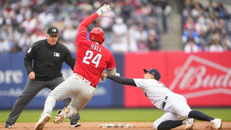 Apr 5, 2023; Bronx, New York, USA; New York Yankees shortstop Anthony Volpe (11) tags out Philadelphia Phillies first baseman Darick Hall (24) trying to stretch a single into a double during the fourth inning at Yankee Stadium. Mandatory Credit: Gregory Fisher-USA TODAY Sports