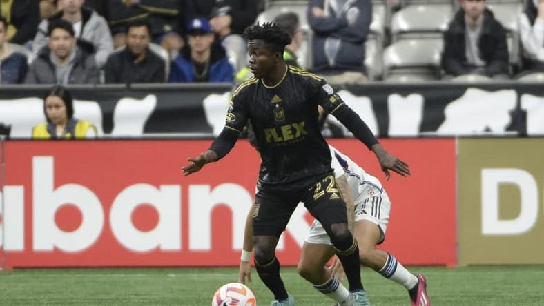 Apr 5, 2023; Vancouver, British Columbia, CAN; Los Angeles FC forward Kwadwo Opoku (22) takes possession of the ball against Vancouver Whitecaps FC defender Ryan Raposo (27) during the first half at BC Place. Mandatory Credit: Anne-Marie Sorvin-USA TODAY Sports
