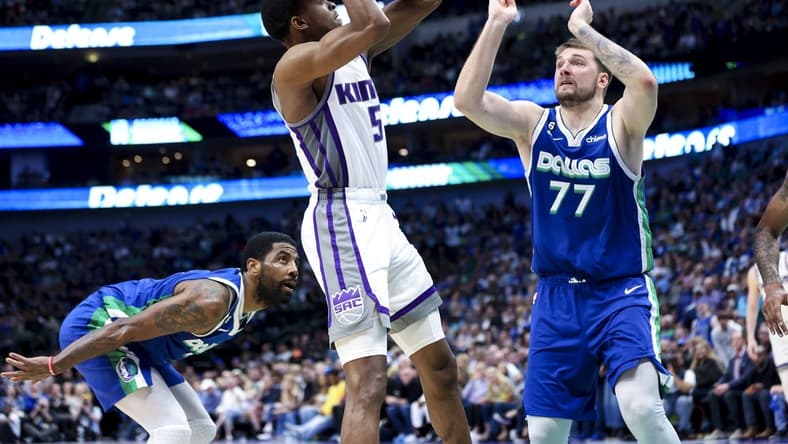 Apr 5, 2023; Dallas, Texas, USA;  Sacramento Kings guard De'Aaron Fox (5) shoots as Dallas Mavericks guard Kyrie Irving (2) and Dallas Mavericks guard Luka Doncic (77) defend during the fourth quarter at American Airlines Center. Mandatory Credit: Kevin Jairaj-USA TODAY Sports