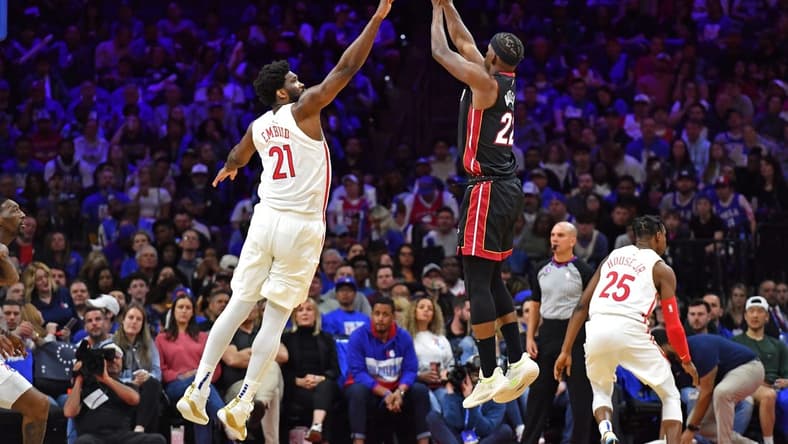 Apr 6, 2023; Philadelphia, Pennsylvania, USA; Miami Heat forward Jimmy Butler (22) shoots a three pointer shot over Philadelphia 76ers center Joel Embiid (21) during the third quarter at Wells Fargo Center. Mandatory Credit: Eric Hartline-USA TODAY Sports