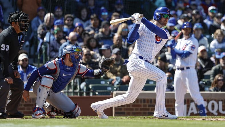 Apr 7, 2023; Chicago, Illinois, USA; Chicago Cubs center fielder Cody Bellinger (24) hits an RBI-single against the Texas Rangers during the fourth inning at Wrigley Field. Mandatory Credit: Kamil Krzaczynski-USA TODAY Sports